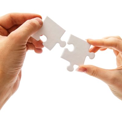 Girl holding white puzzle on a white background